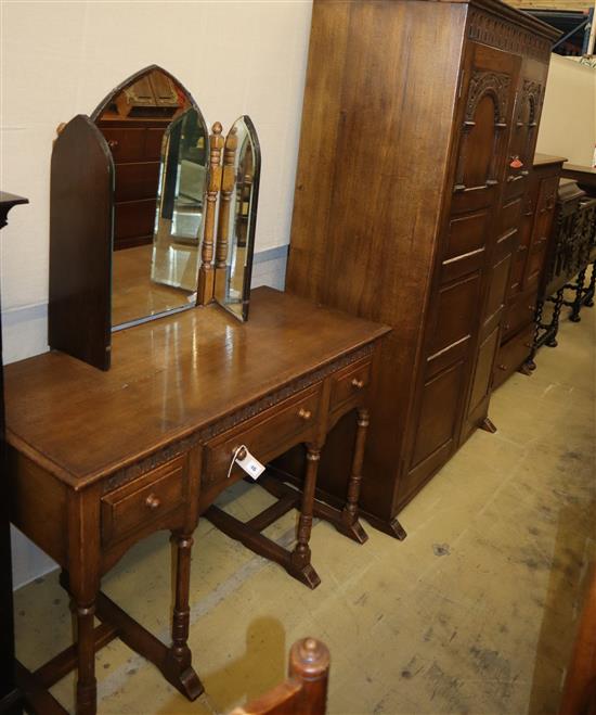 A carved and panelled oak wardrobe fitted two doors with matching compactum and dressing table, wardrobe W.104cm, D.55cm, H.178cm